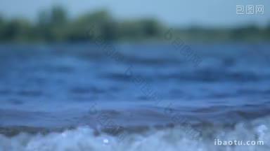 特写清澈的水面与波纹低波在模糊的景观背景水平拍摄